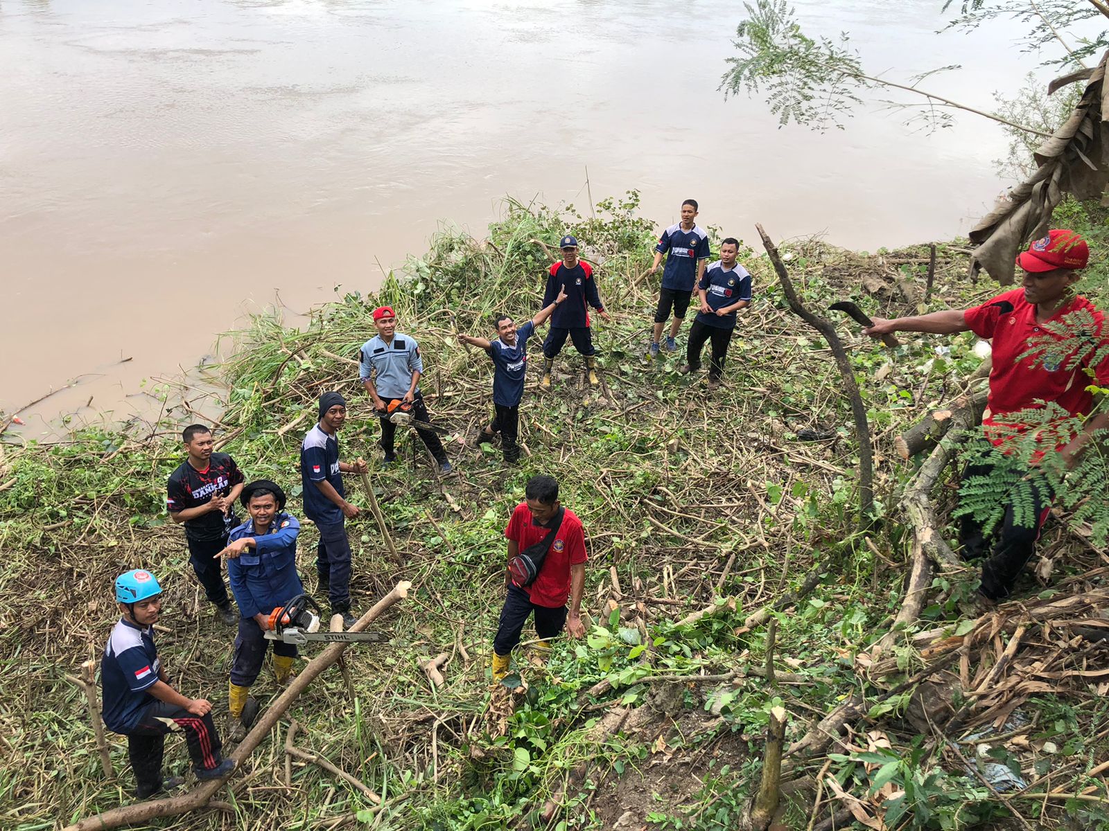 Antisipasi Kemunculan Buaya,Petugas DAMKARMAT Dibantu Warga Bersihkan Bantaran Sungai Bengawan Solo.
