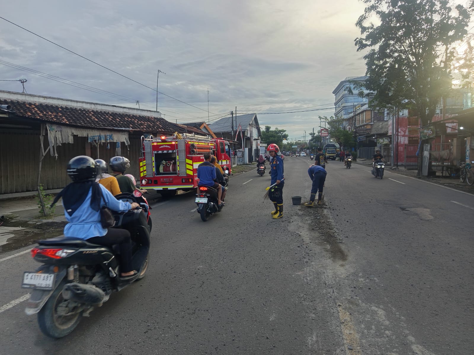 Petugas Damkarmat Bojonegoro Lakukan Pembersihan Tumpahan Cor di Jalan Raya Sumberrejo