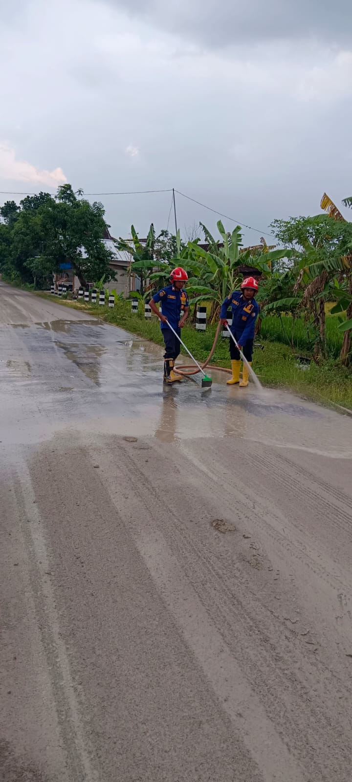 Damkarmat Bojonegoro Lakukan Penyemprotan Sisa Tanah di Jalan Raya Mulyorejo