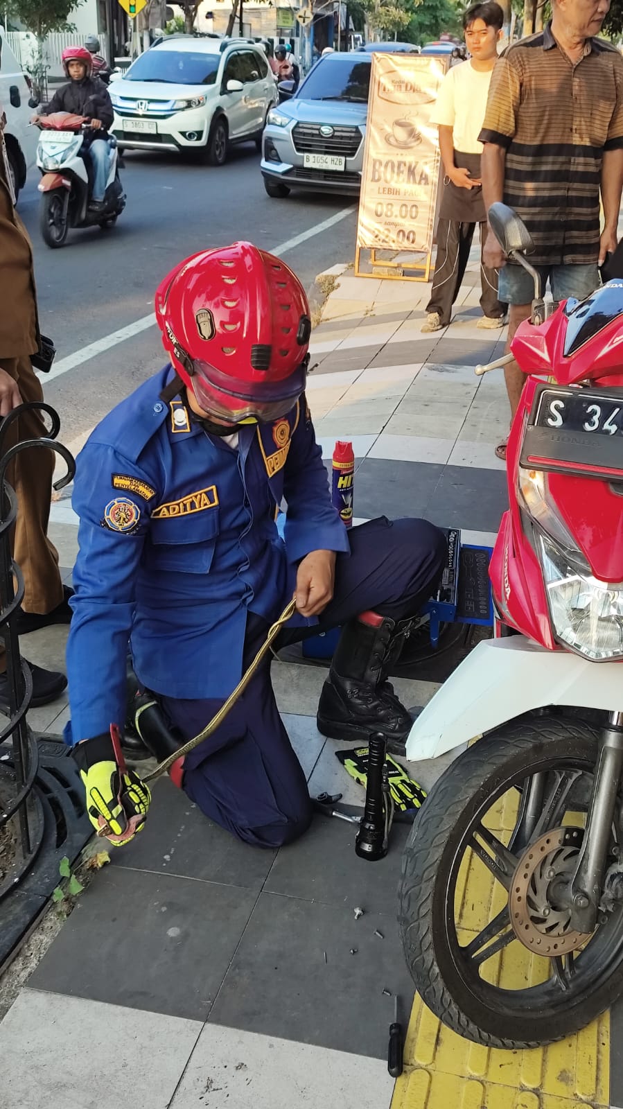 Petugas Damkarmat Bojonegoro Evakuasi Ular dari Body Sepeda Motor Warga