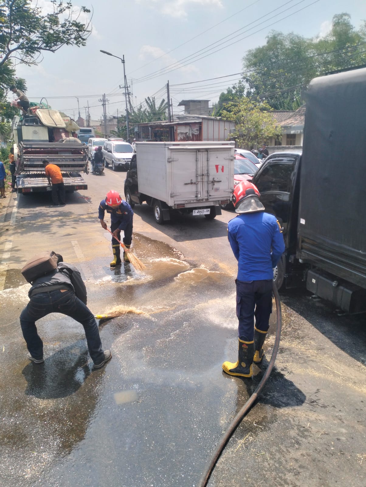 Damkarmat Bojonegoro Bersihkan Tumpahan Solar di Jalan Raya Balen.